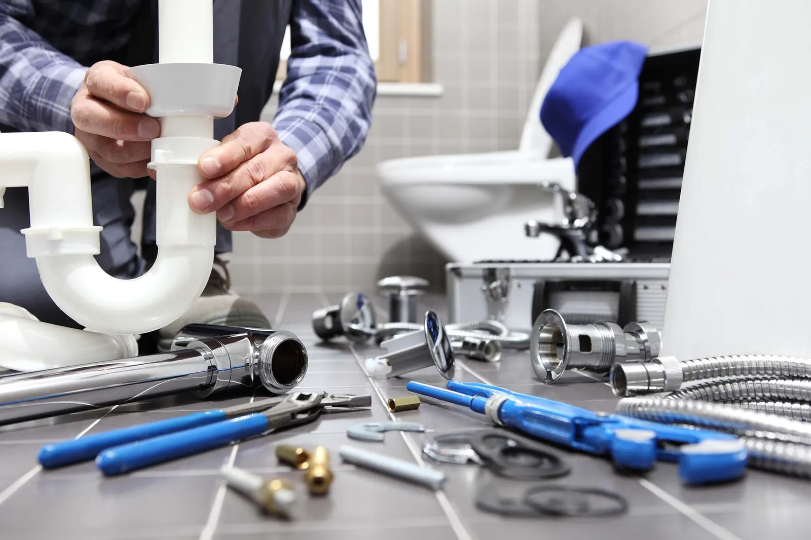 Plumber fixing a u bend in a toilet